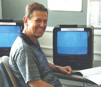 Mature male student working on video materials, smiling 