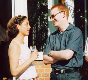 Two young people talking, smiling, in sunlight in St Clare's garden