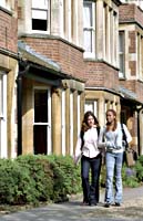 Two St Clare's students in front of St Clare's building