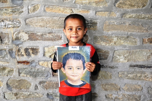 Santosh receiving his portrait by St. Clare's Visual Art student