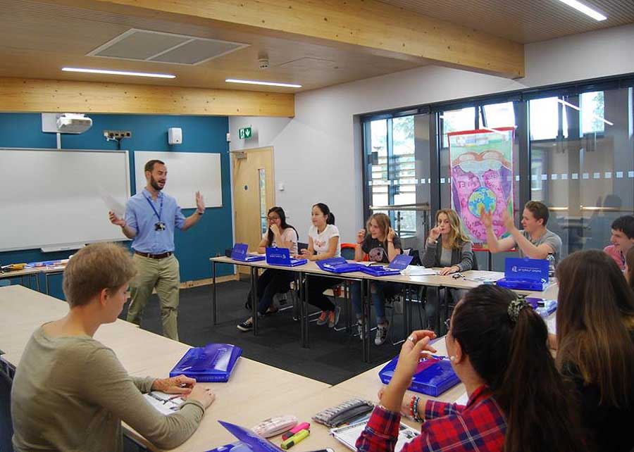 students at desks in classroom with teacher