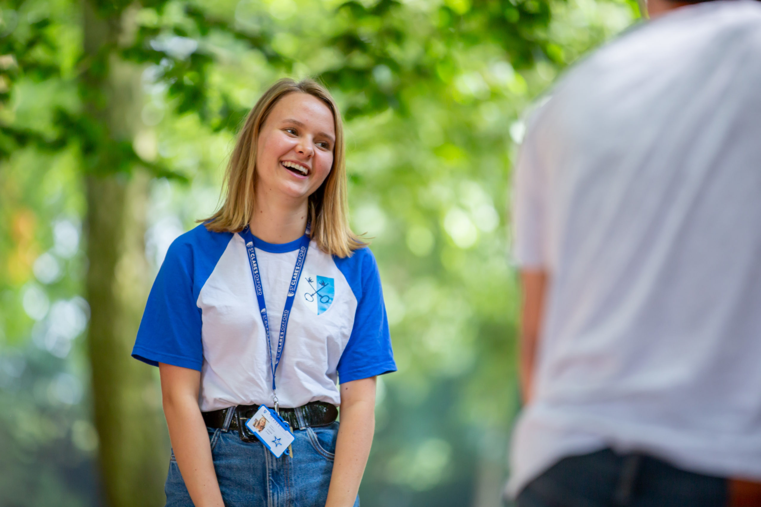 A group of student in red t-shirts in sunshine in a garden